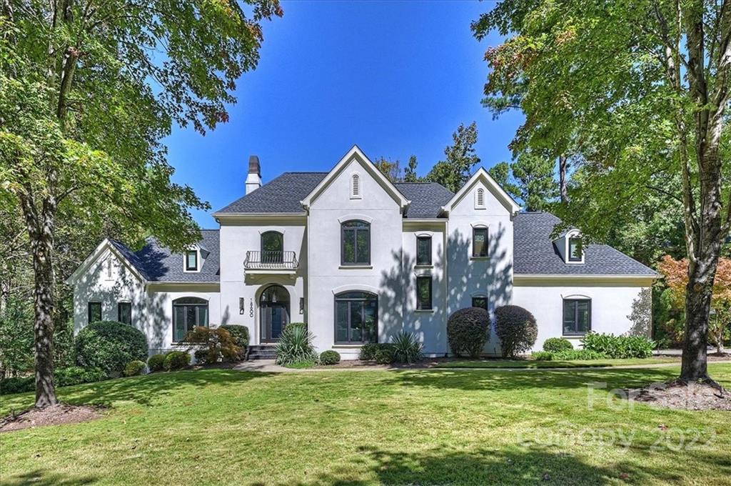a front view of a house with a garden and trees