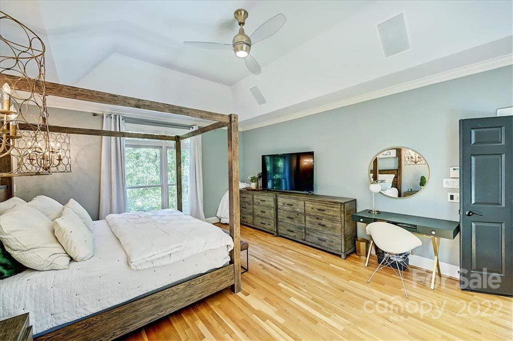 18600 Hammock Lane Davidson, NC 28036 - Photo 21 of 48 a bedroom with a bed a chandelier and a flat screen tv