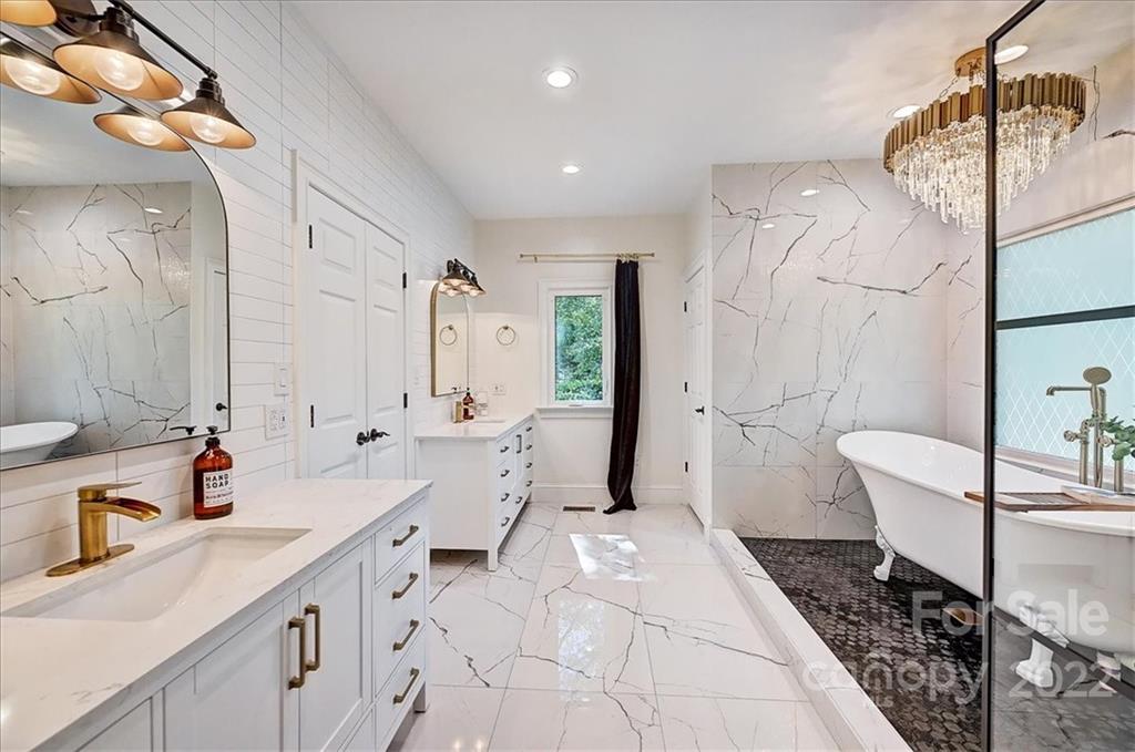18600 Hammock Lane Davidson, NC 28036 - Photo 24 of 48 a spacious bathroom with a double vanity sink a toilet a mirror and shower