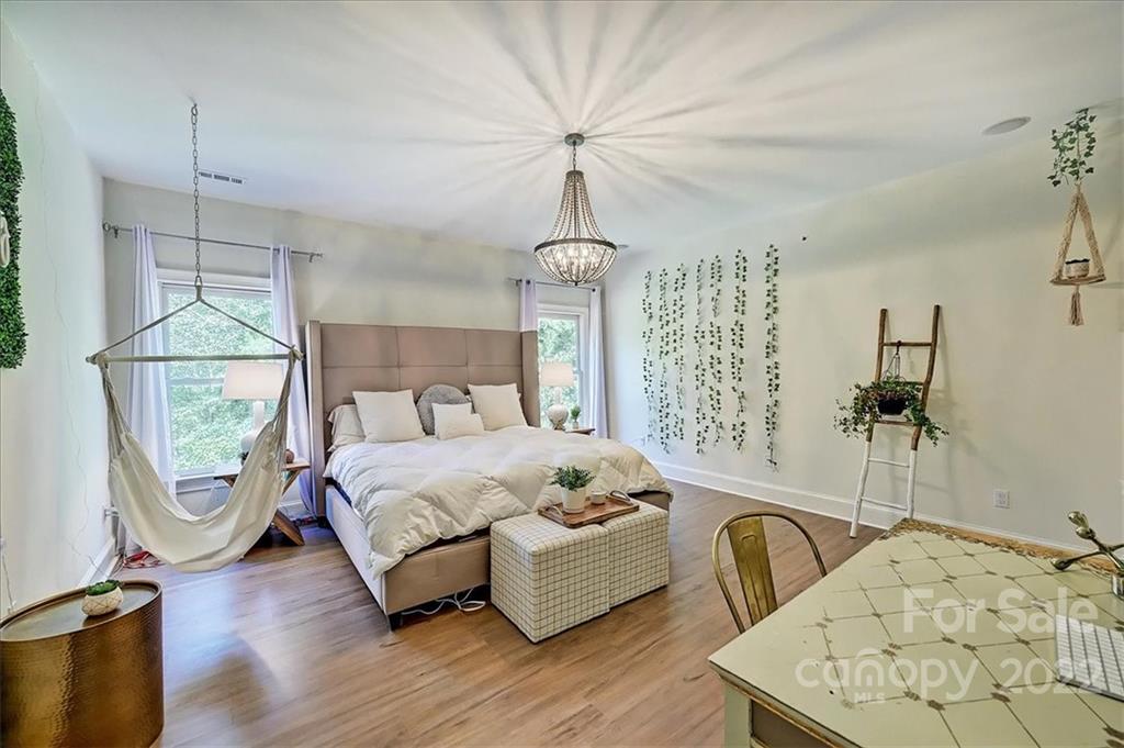 18600 Hammock Lane Davidson, NC 28036 - Photo 31 of 48 a spacious bedroom with a bed a chandelier and couch