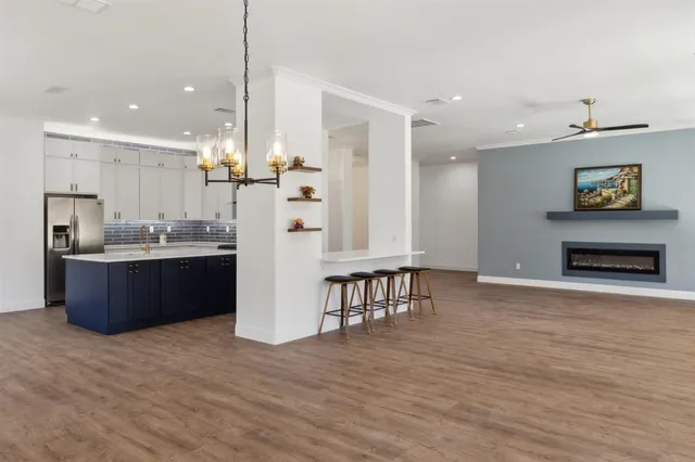 a kitchen with kitchen island a island a stove a refrigerator and a sink