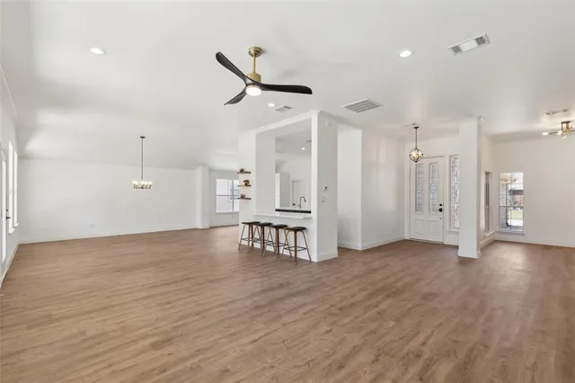 a view of a kitchen with kitchen island a sink wooden floor and a fireplace