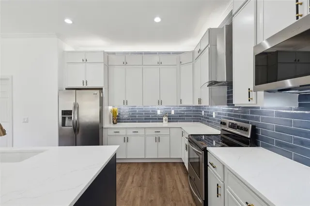 a view of a hallway with wooden floor and a kitchen