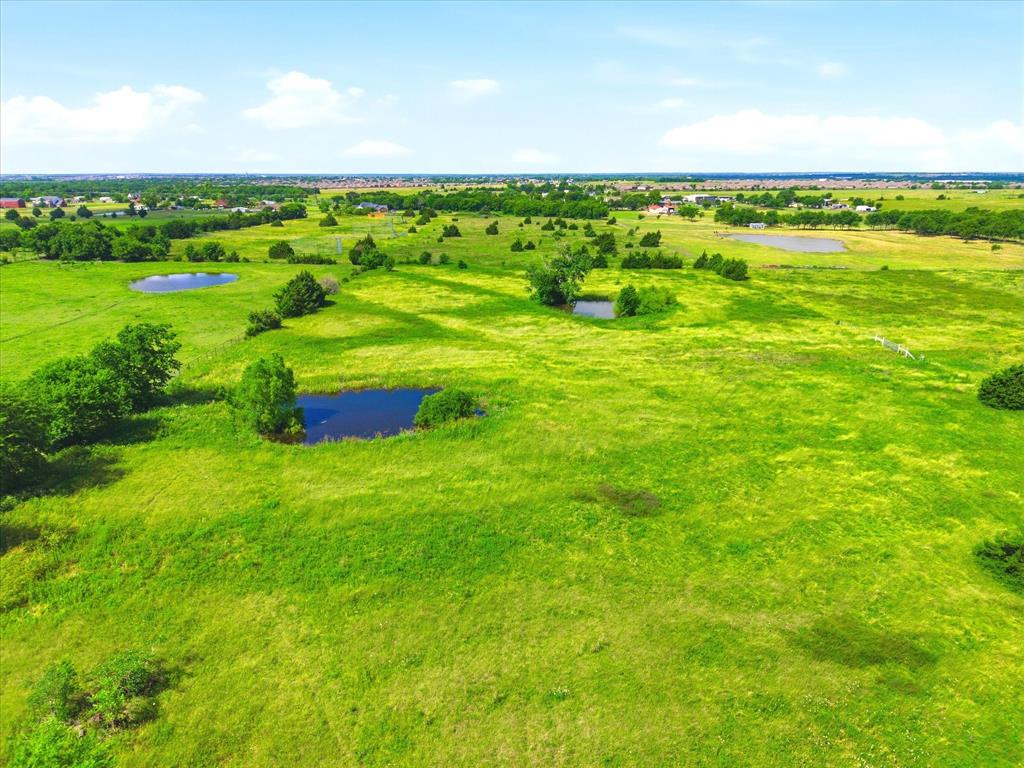 11749 Windy Lane Forney, TX 75126 - Photo 6 of 8 Expansive green landscape featuring multiple ponds and scattered mature trees