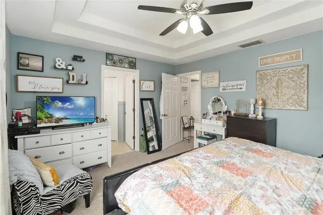 a bedroom with a bed and a flat tv screen on dresser