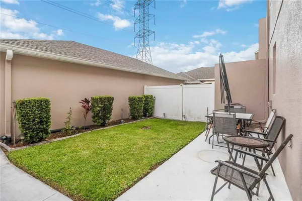 a backyard of a house with table and chairs