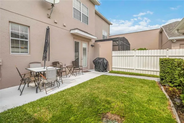 a view of a patio with table and chairs with plants and wooden fence