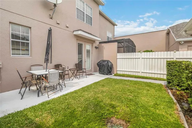 a view of a patio with table and chairs with plants and wooden fence