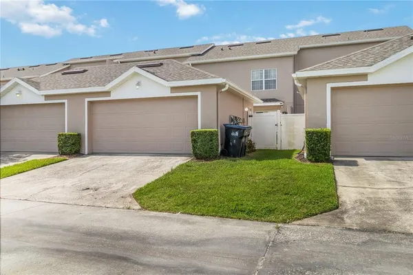 a view of a white house with a small yard and a garage