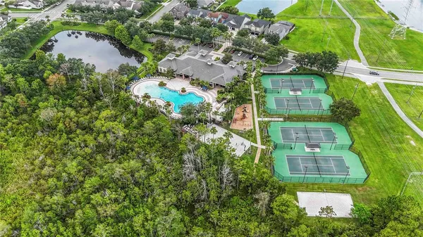 an aerial view of residential houses with outdoor space and trees