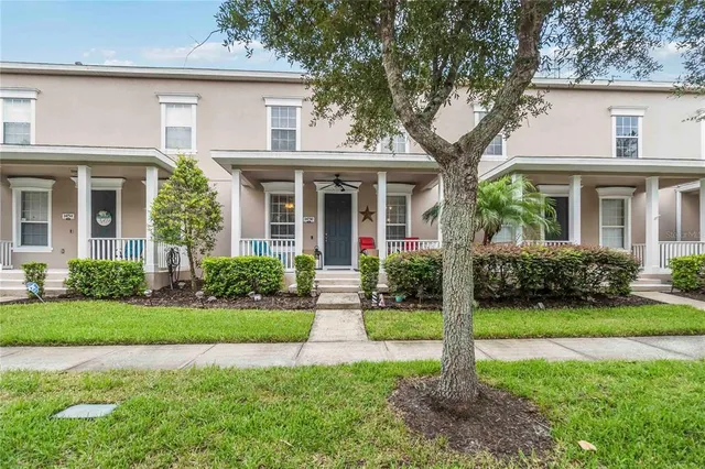 a front view of a house with a yard and potted plants