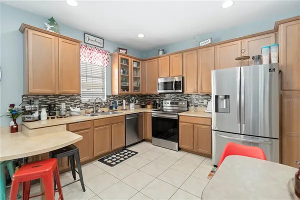 a kitchen with stainless steel appliances granite countertop a refrigerator sink and stove