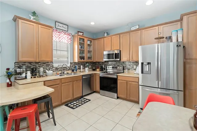 a kitchen with stainless steel appliances granite countertop a refrigerator sink and stove