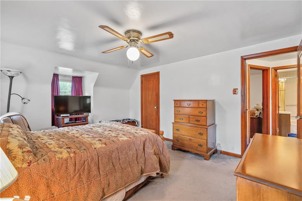 1031 Anderson Road Pittsburgh, PA 15209 - Photo 19 of 35 a bedroom with a bed and a chandelier