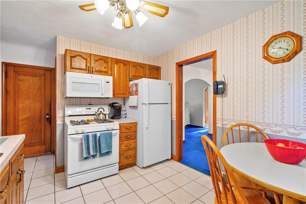 1031 Anderson Road Pittsburgh, PA 15209 - Photo 8 of 35 a kitchen with stainless steel appliances granite countertop a refrigerator a stove a sink dishwasher and a dining table with wooden floor