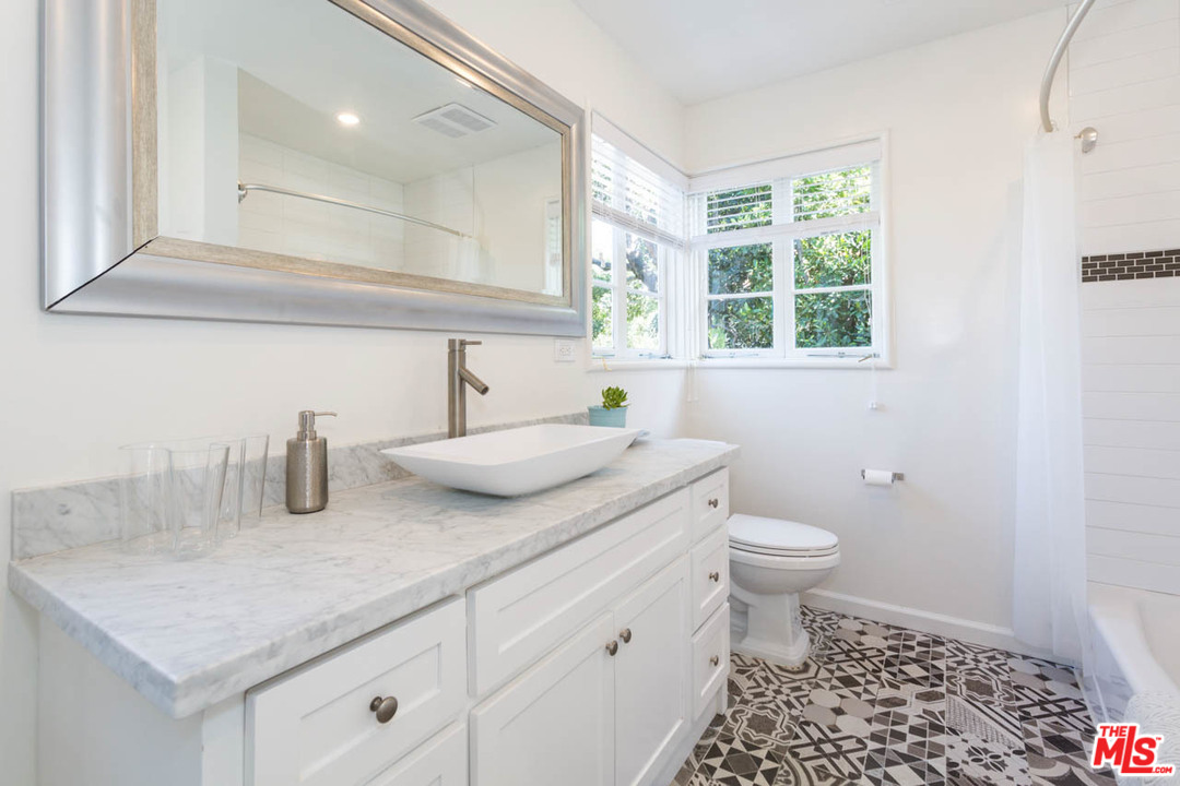 5 Richland Place Pasadena, CA 91103 - Photo 21 of 54 a bathroom with a granite countertop sink a toilet and a window