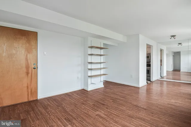a view of a room with wooden floor and white walls