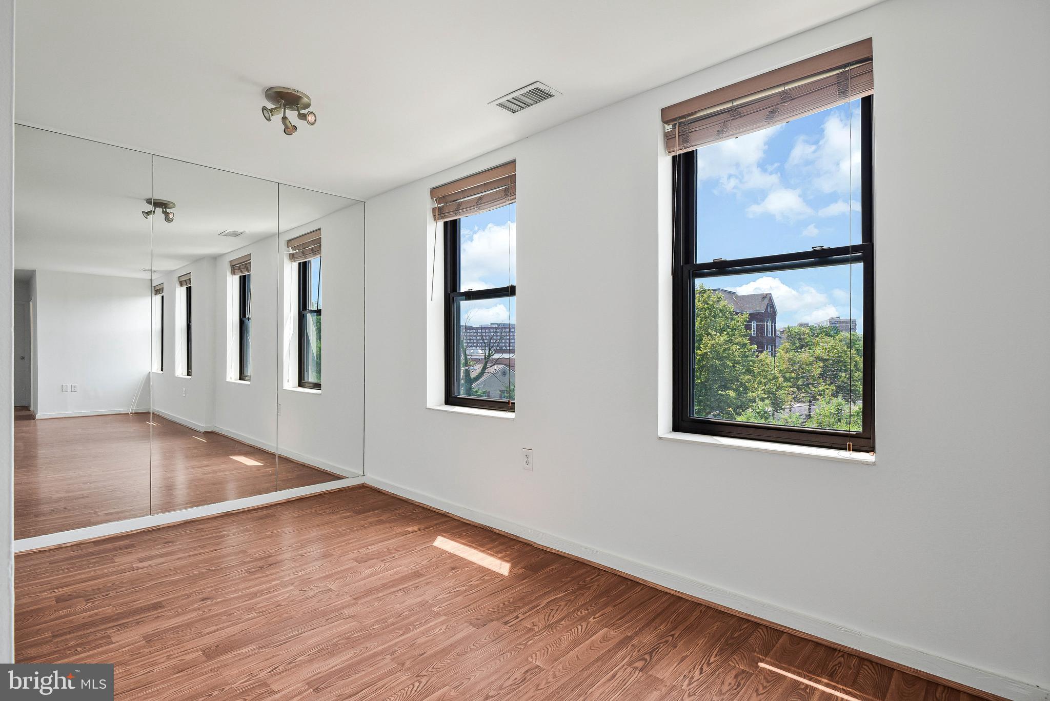 80 New York Avenue Northwest, Unit 303 Washington, DC 20001 - Photo 14 of 27 a view of an empty room with wooden floor and a window