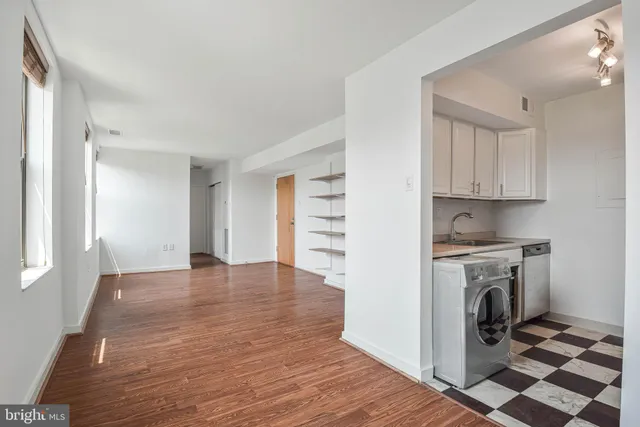 a view of a kitchen with wooden floor and stainless steel appliances