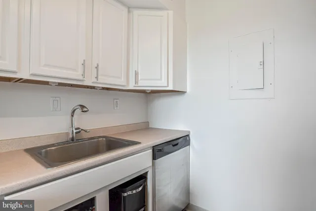 a kitchen with white cabinets and a sink
