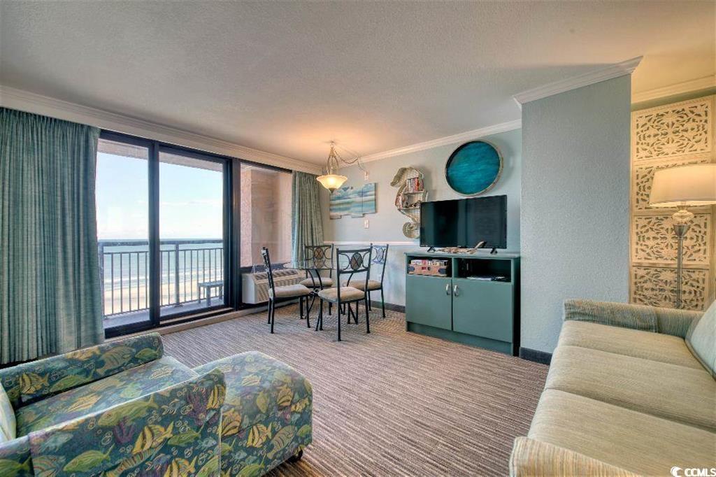 6900 North Ocean Boulevard, Unit 611 Myrtle Beach, SC 29572 - Photo 3 of 17 Carpeted living room with crown molding, a textured ceiling, and floor to ceiling windows