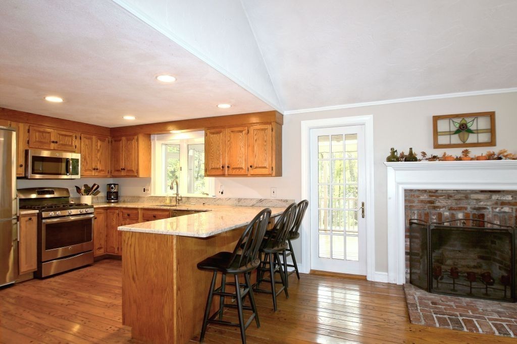 41 Campbell Road Wayland, MA 01778 - Photo 5 of 24 a kitchen with granite countertop a stove top oven a sink a dining table and chairs