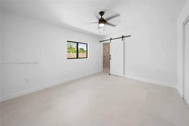 en empty room with ceiling fan and window
