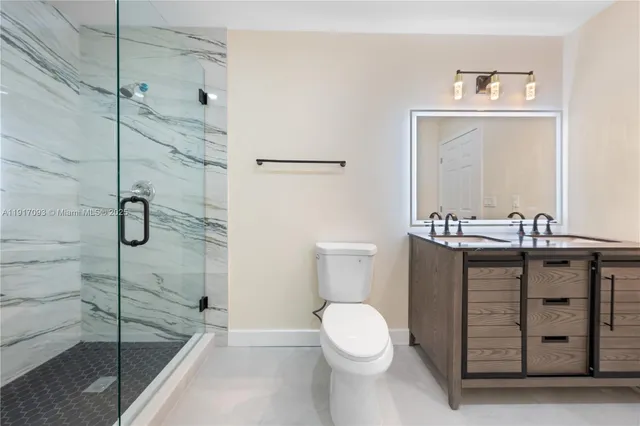 a bathroom with a double vanity sink toilet and shower