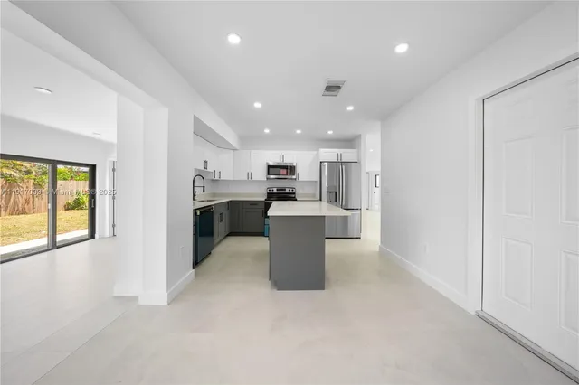 a large kitchen with a large counter top appliances and cabinets
