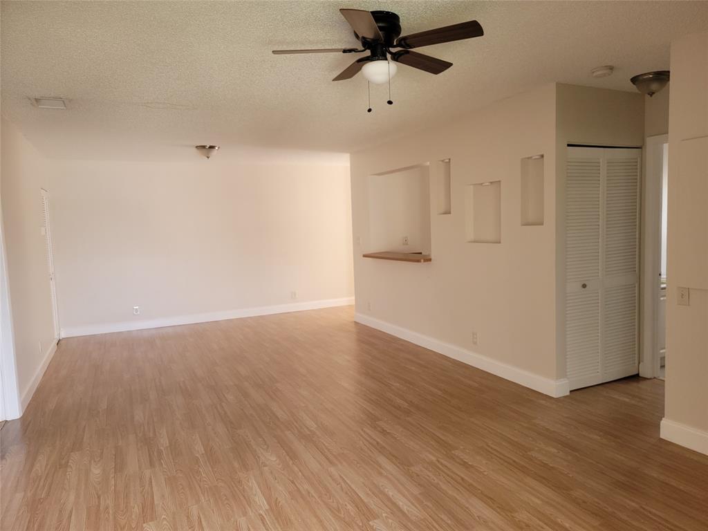 12255 Royal Palm Boulevard, Unit 8O Coral Springs, FL 33065 - Photo 6 of 15 a view of a room with wooden floor and a ceiling fan