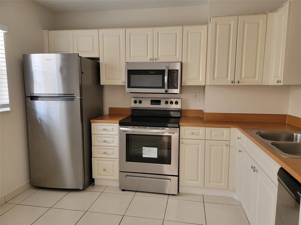12255 Royal Palm Boulevard, Unit 8O Coral Springs, FL 33065 - Photo 7 of 15 a kitchen with white cabinets and stainless steel appliances