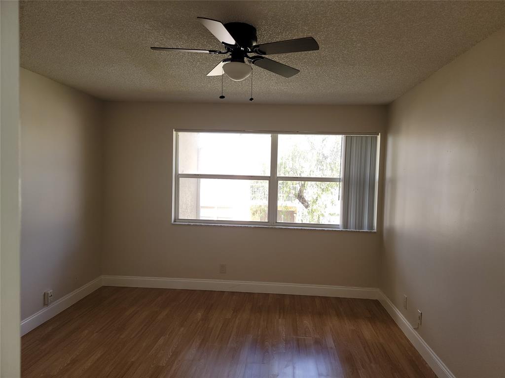 12255 Royal Palm Boulevard, Unit 8O Coral Springs, FL 33065 - Photo 10 of 15 an empty room with wooden floor and windows