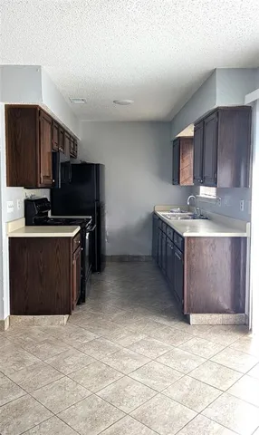 a kitchen with stainless steel appliances a sink a stove a microwave a counter top and cabinets