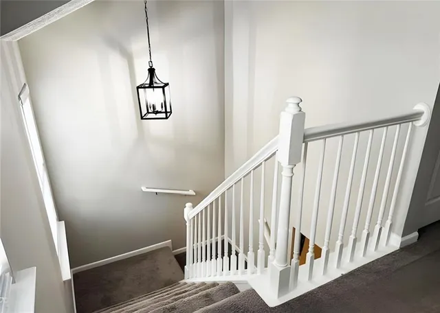 a view of staircase with railing and white walls