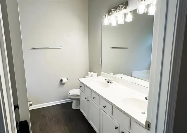 a spacious bathroom with a sink a toilet and a mirror