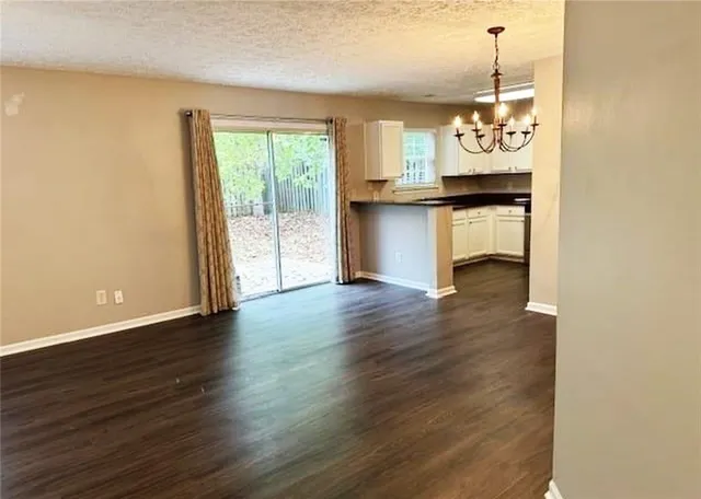 a view of a kitchen with wooden floor and a window