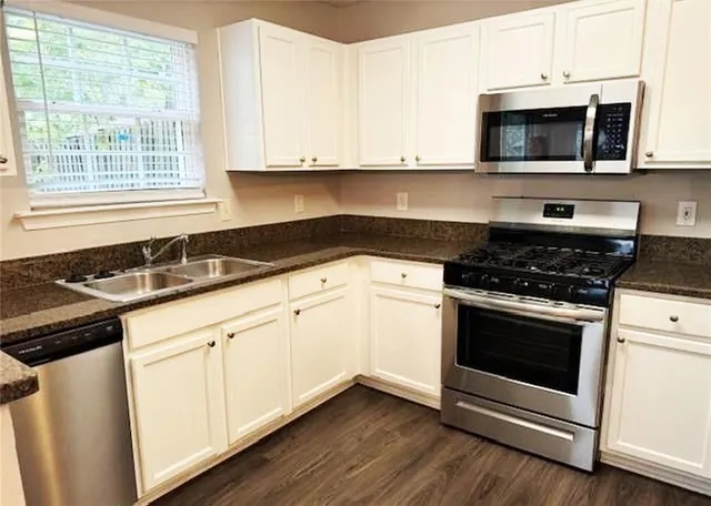 a kitchen with granite countertop a stove and a microwave