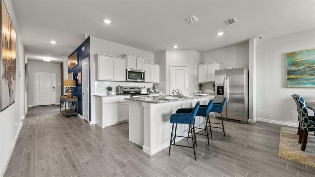 244 Kinley Street Grandview, TX 76050 - Photo 30 of 32 a kitchen with white cabinets and stainless steel appliances