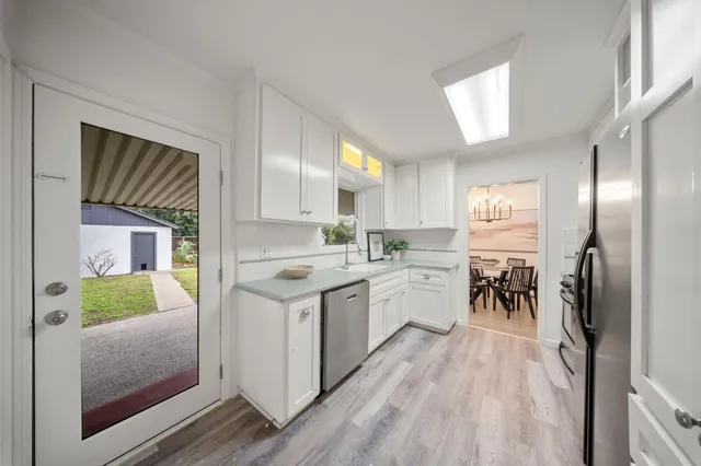 a kitchen with a refrigerator a sink and a stove top oven