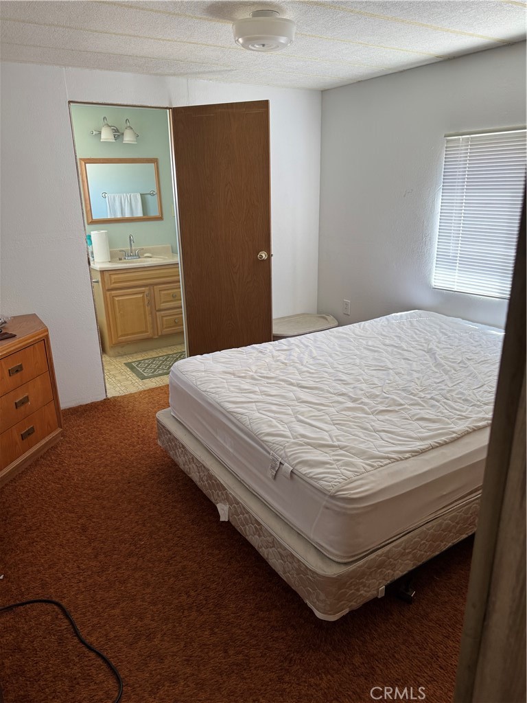 10369 Fairlane Road Lucerne Valley, CA 92356 - Photo 4 of 12 a bedroom with a bed and wooden floor