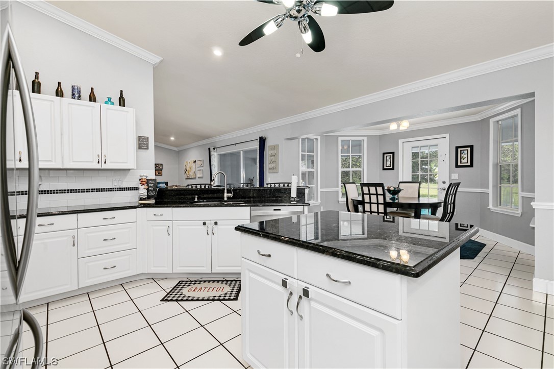 17571 Oak Creek Road Alva, FL 33920 - Photo 15 of 49 a kitchen with stainless steel appliances granite countertop white cabinets and window