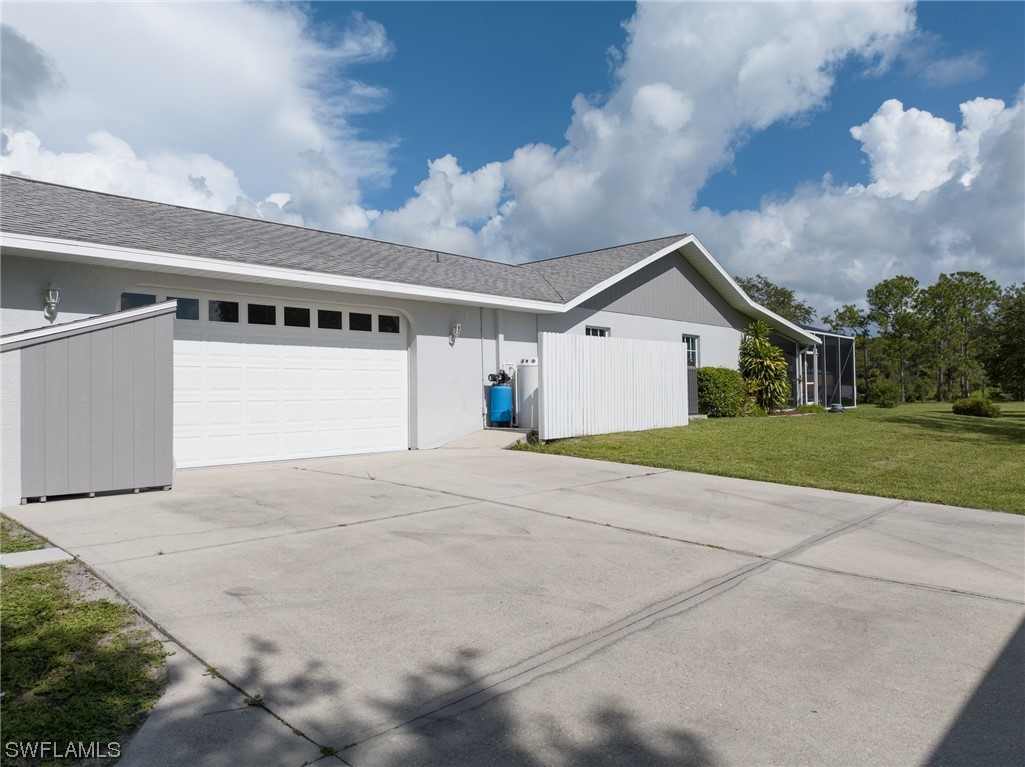17571 Oak Creek Road Alva, FL 33920 - Photo 32 of 49 a view of a white house with a yard and potted plants