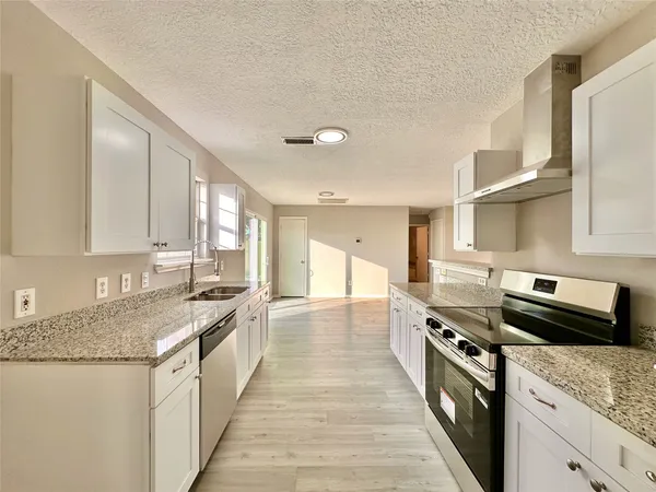a kitchen with stainless steel appliances granite countertop a sink stove and cabinets