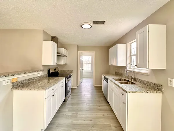 a kitchen with sink stove and cabinets