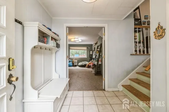 a view of a hallway to a livingroom with wooden floor and furniture
