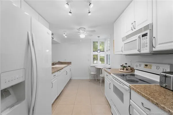 a spacious kitchen with stainless steel appliances granite countertop a sink stove and refrigerator