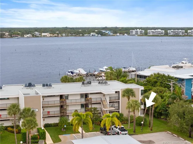 an aerial view of residential houses with outdoor space and lakeside