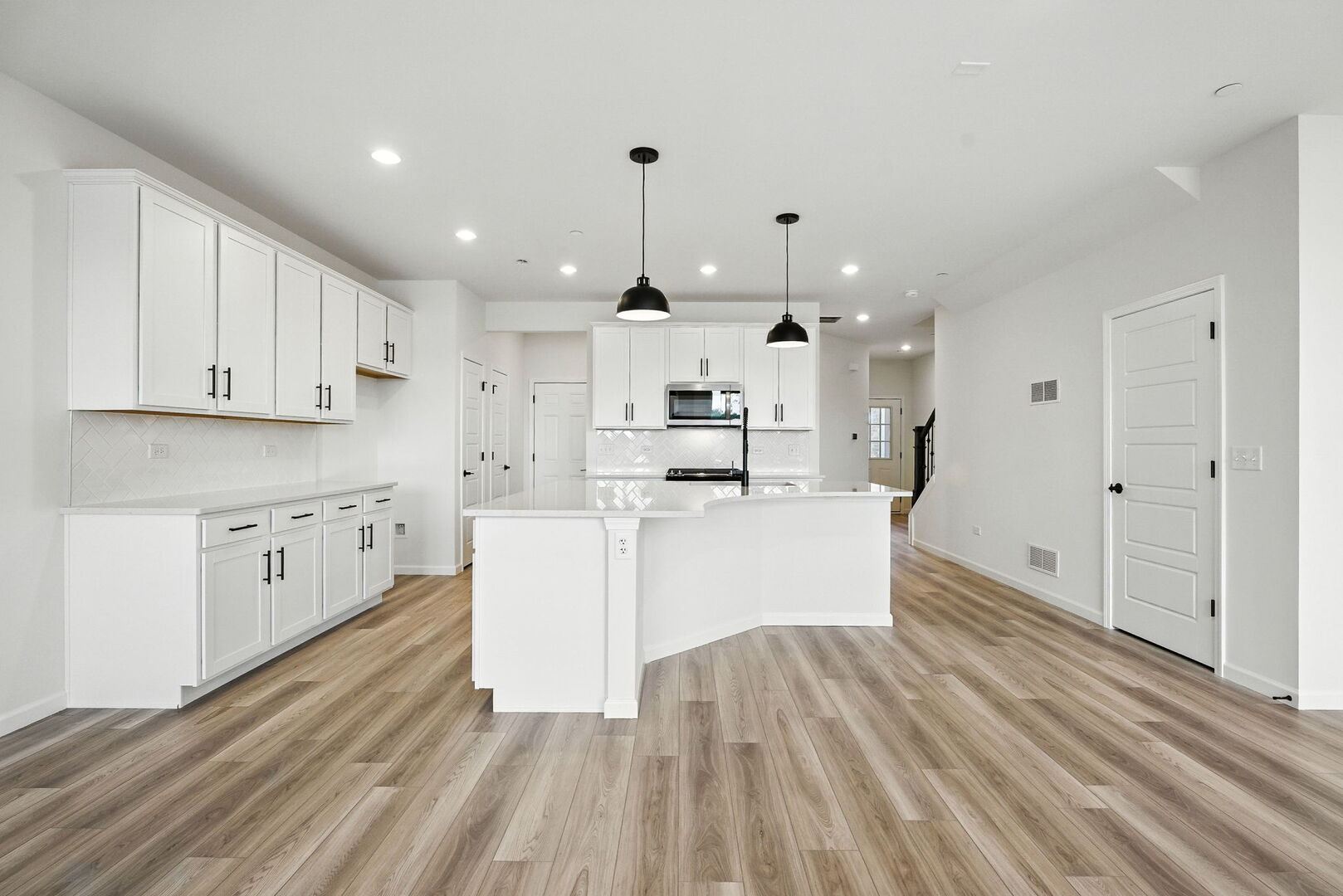 1062 Houston Street, Unit 74004 Batavia, IL 60510 - Photo 8 of 23 a large white kitchen with kitchen island a sink dishwasher a stove a refrigerator and white cabinets with wooden floor
