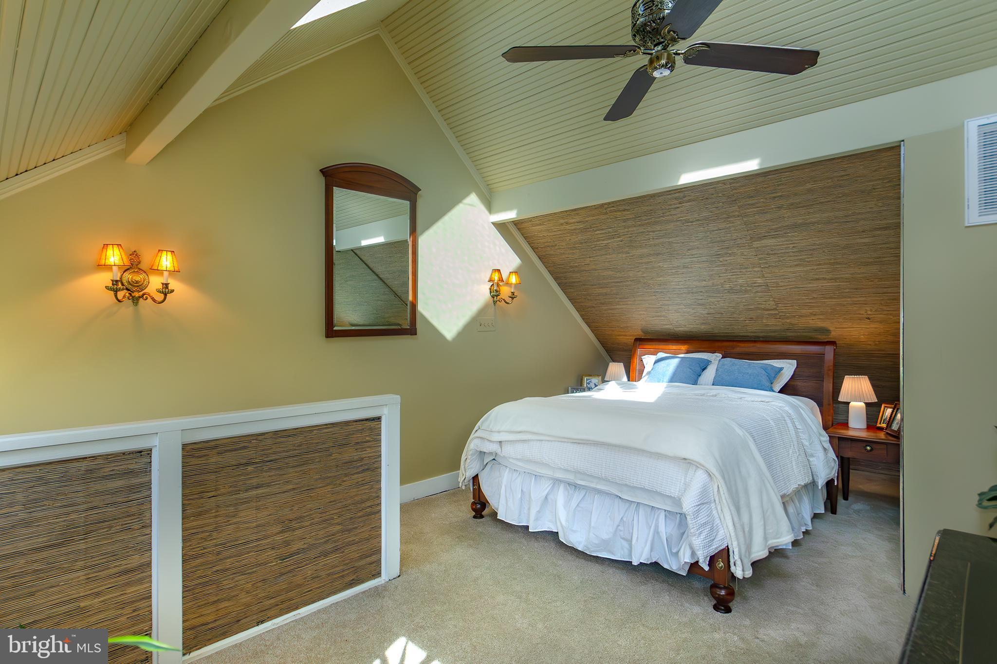 10108 Falls Road Lutherville-Timonium, MD 21093 - Photo 32 of 55 a bedroom with a bed lamp and paintings on the wall