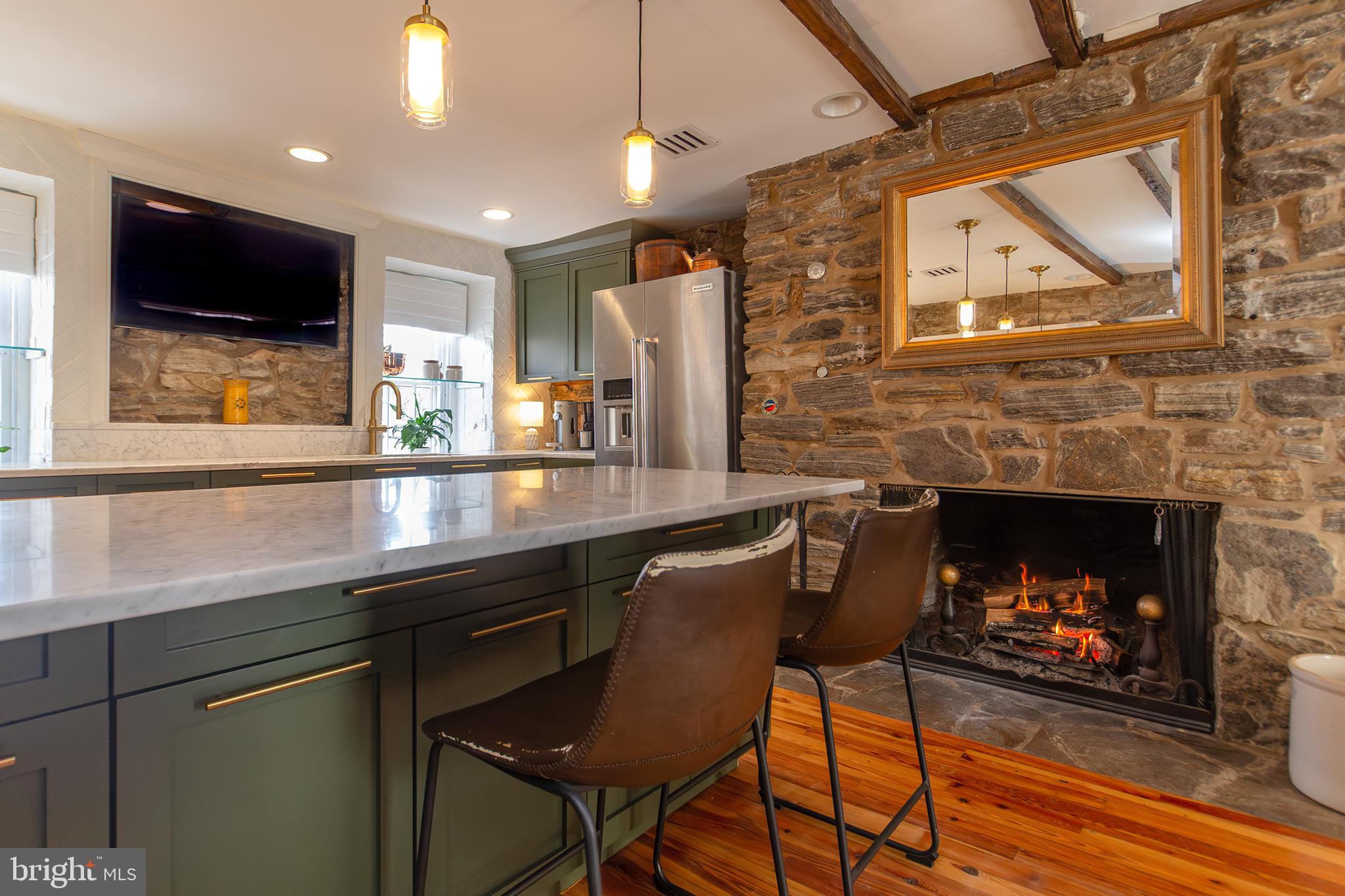 10108 Falls Road Lutherville-Timonium, MD 21093 - Photo 7 of 55 a kitchen with a wooden floor and a fireplace